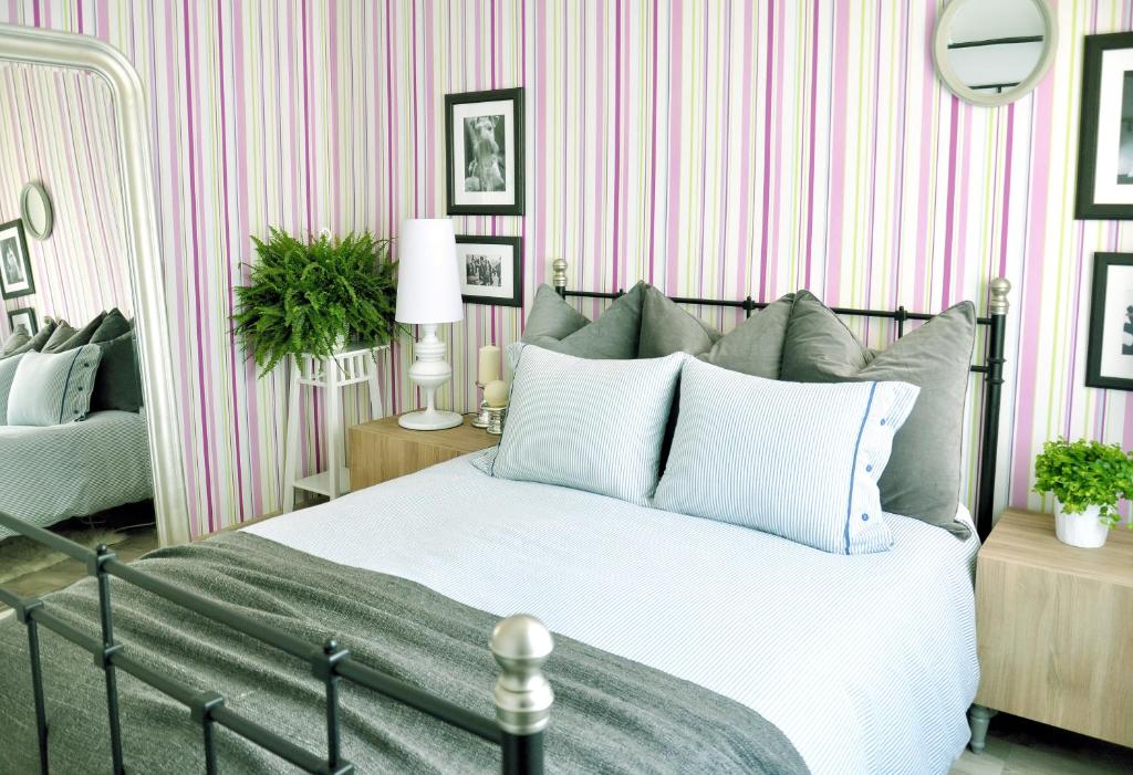 巴塞罗那精品经济酒店的卧室配有一张床,并拥有粉色和白色条纹