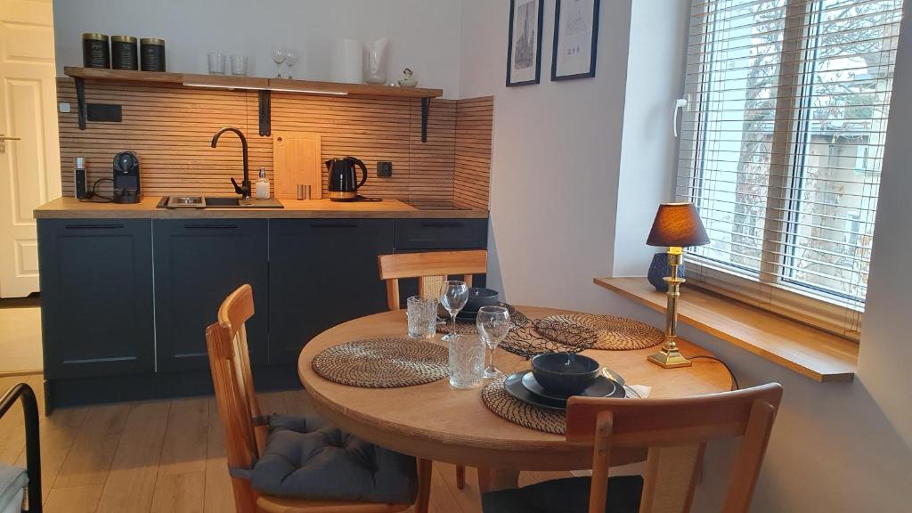 西维德尼察Apartament Wieżyczka的一间带木桌和椅子的厨房以及一间用餐室