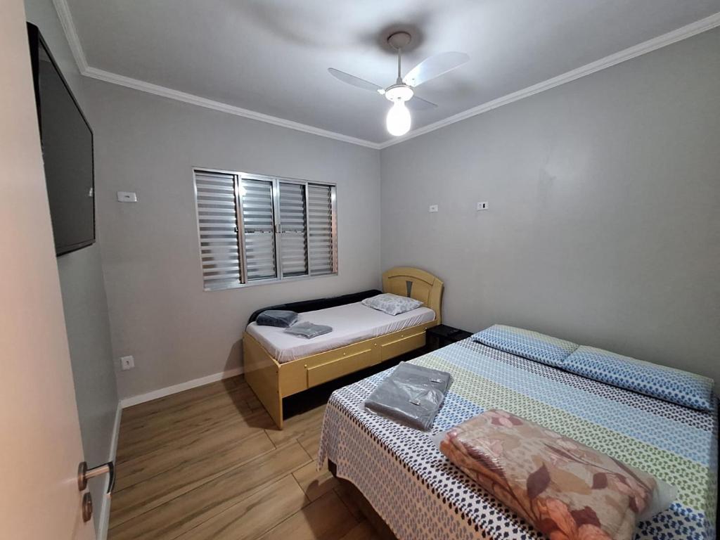 瓜鲁柳斯Hostel My House quartos perto do aeroporto de Guarulhos的一间卧室配有两张床和吊扇