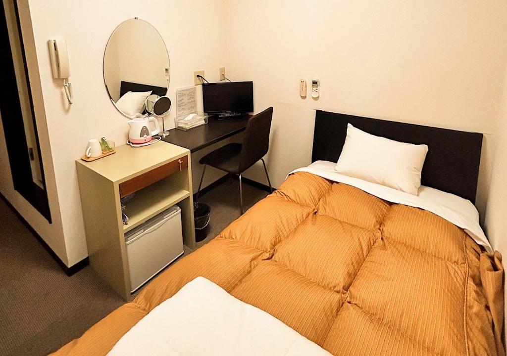 对马市Hotel MitsuWakan - Vacation STAY 87402v的一间卧室配有一张床和一张带镜子的书桌