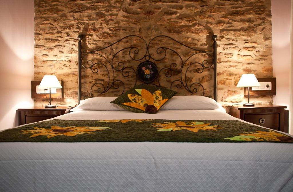 Tirvia卡萨拉柯美拉乡村酒店的一间卧室设有一张带石墙的大床