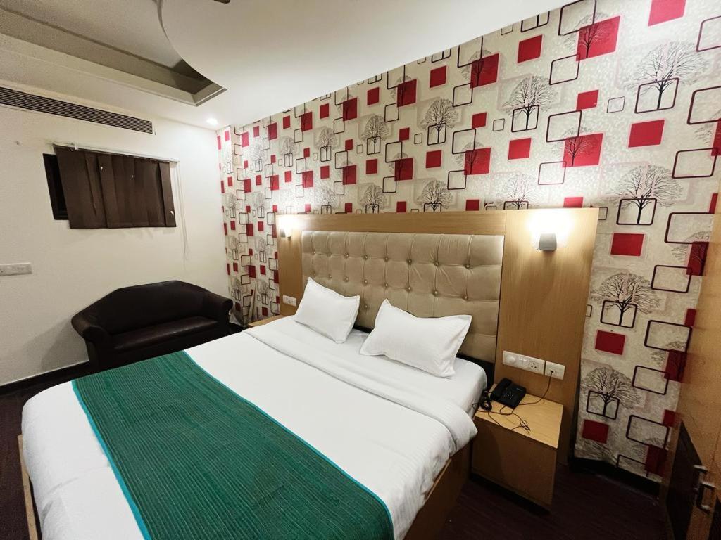 新德里Hotel Diamond Airport的一间卧室设有一张大床和一张带照片的墙壁