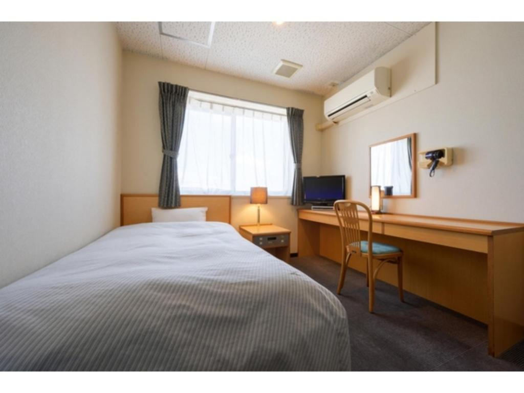 十和田Towada City Hotel - Vacation STAY 85232v的一间卧室配有一张床和一张带电脑的书桌