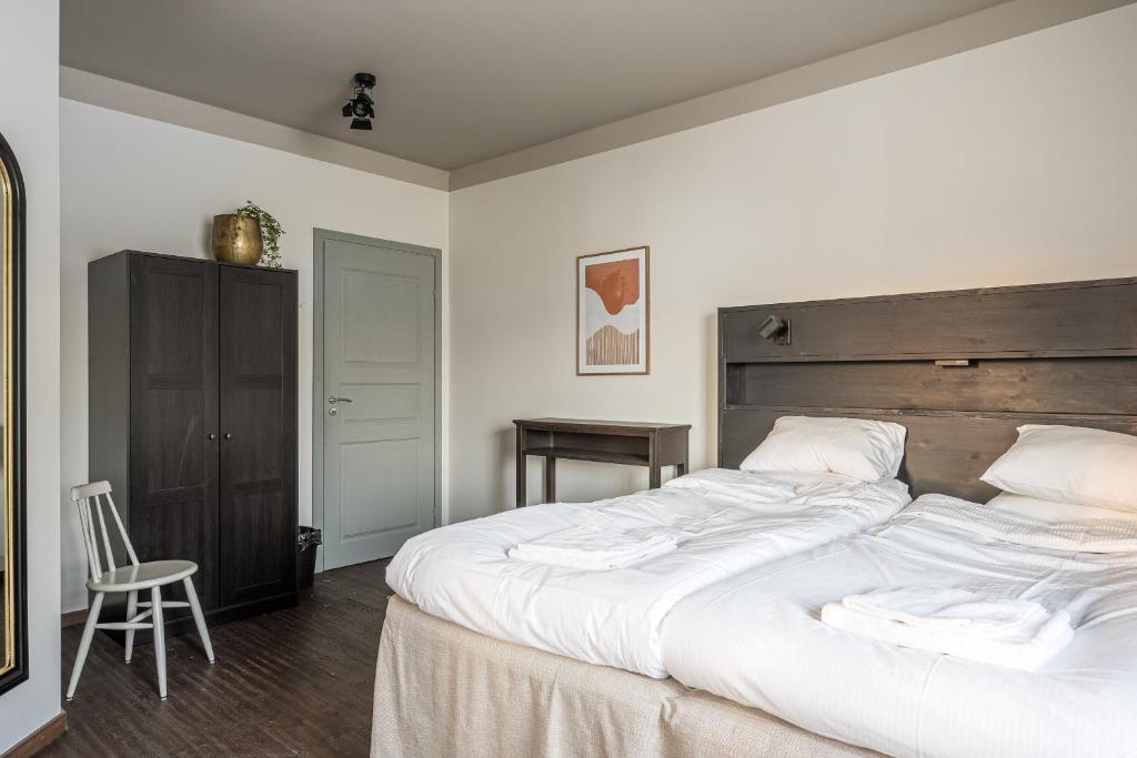 GodbyHotell Grelsby Strand的卧室配有一张白色大床和木制床头板