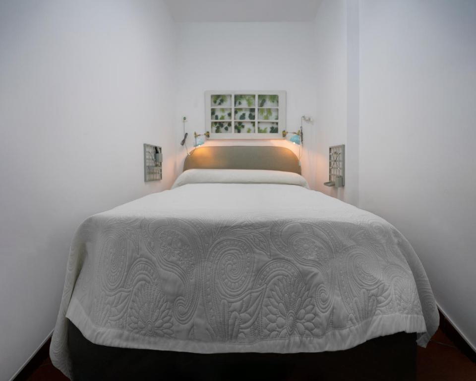 圣克鲁斯-德特内里费Playa Chica Beachfront Apartment的一间卧室配有一张带白色毯子的床