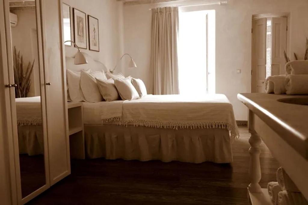 米克诺斯城卡洛格拉旅馆的白色的卧室设有床和窗户