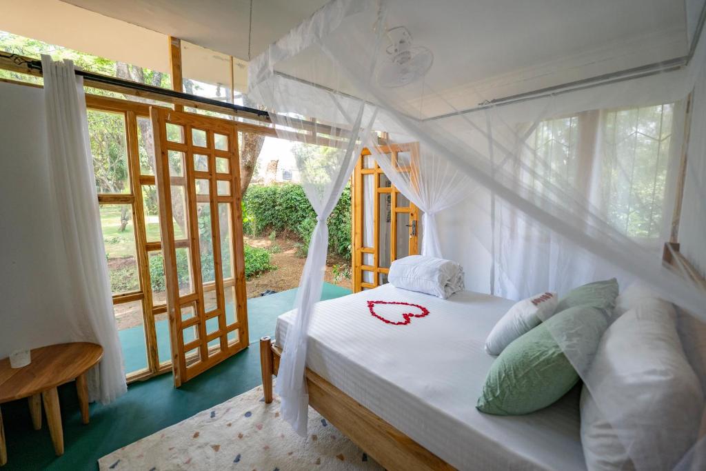 莫希Mkoani Homestay的一间设有床铺的卧室,位于带窗户的房间内