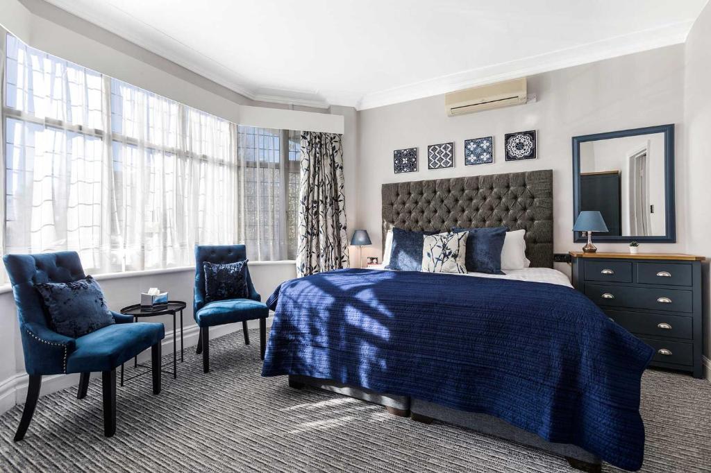 达格纳姆BA TRADERS的一间卧室配有一张床和两张蓝色椅子