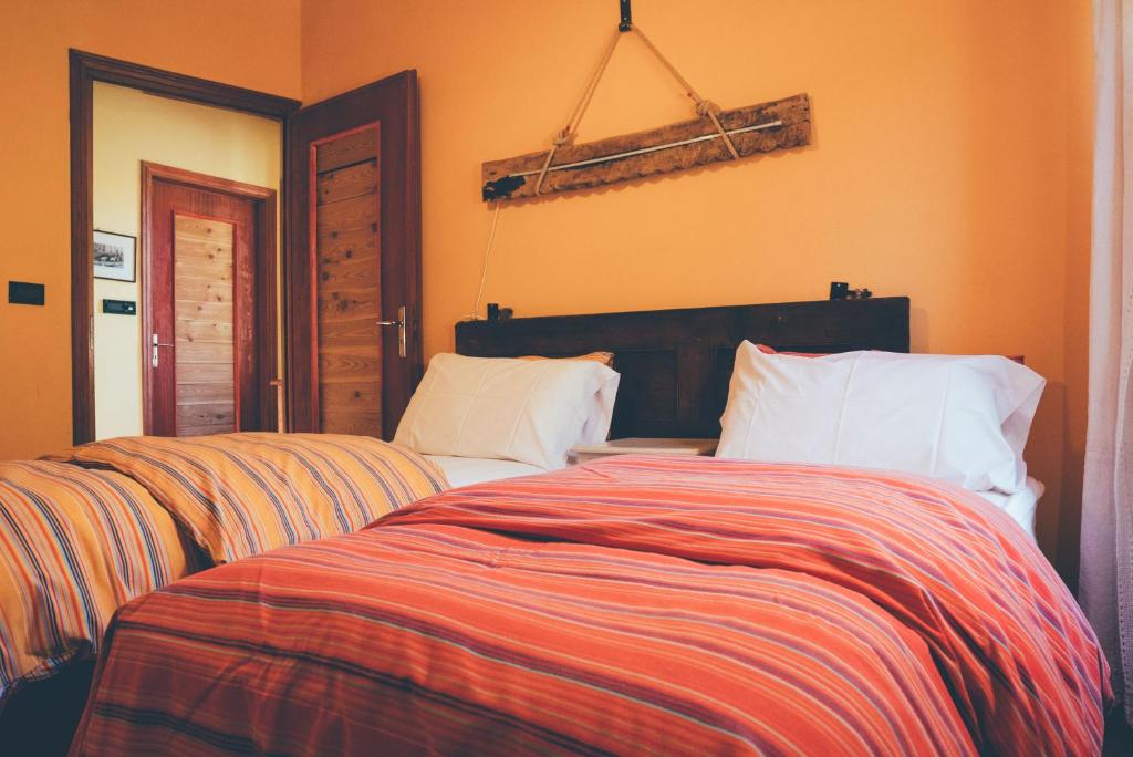 阿尔真泰拉B&B del Villaggio的一间带两张床的卧室,拥有橙色的墙壁