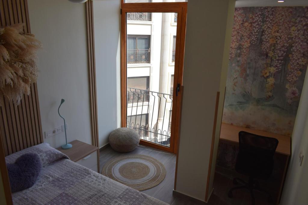 埃尔切Apartamento Ladevesa的一间卧室设有一张床和一个阳台的窗户。