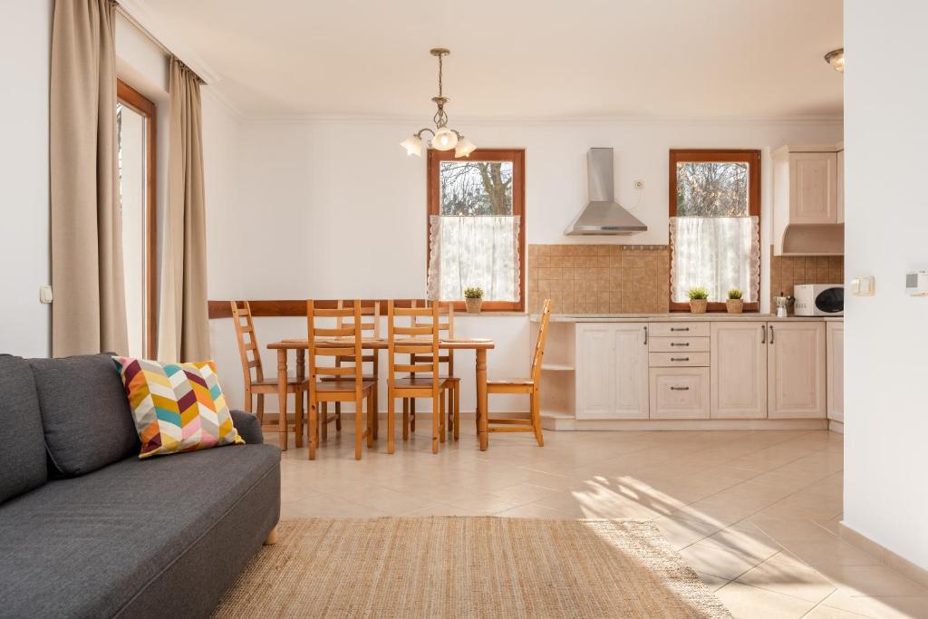 佐洛恰尼Zala Hills Apartman - Batthyány Villapark的厨房以及带桌椅的起居室。