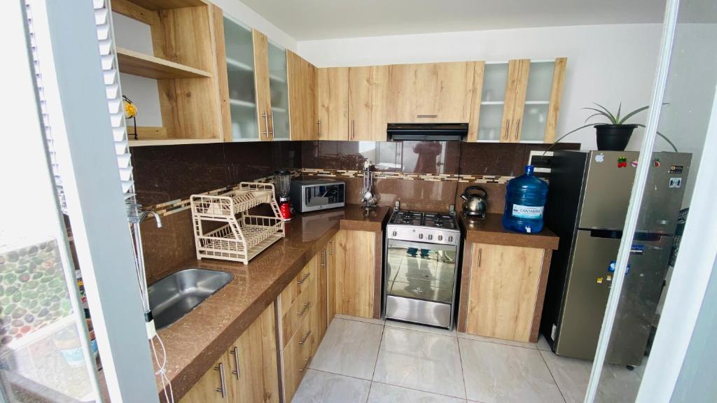 塔克纳Apartamento/Departamento independiente nuevo的厨房配有木制橱柜和不锈钢用具