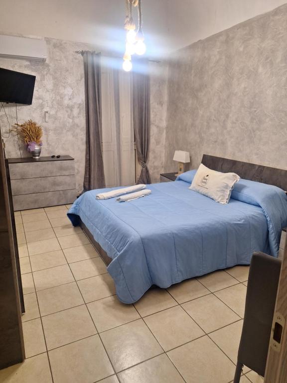 卡塔尼亚Homesweet的一间卧室配有一张带蓝色棉被的床