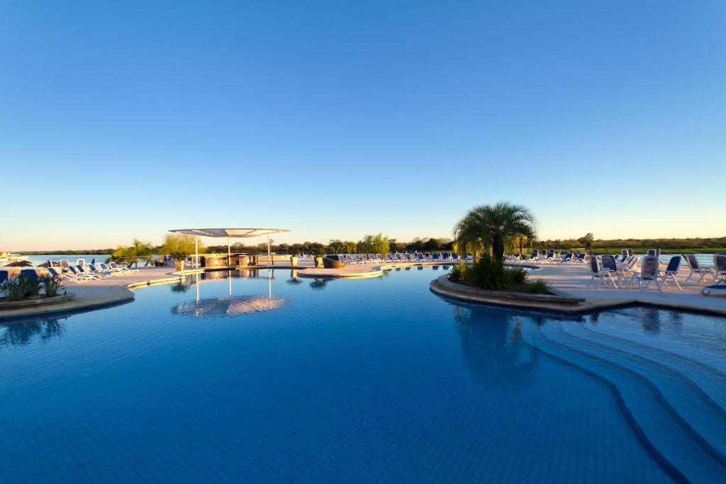 亚松森巴拉圭游艇及高尔夫俱乐部度假酒店的一个带椅子的大型游泳池,一个度假村