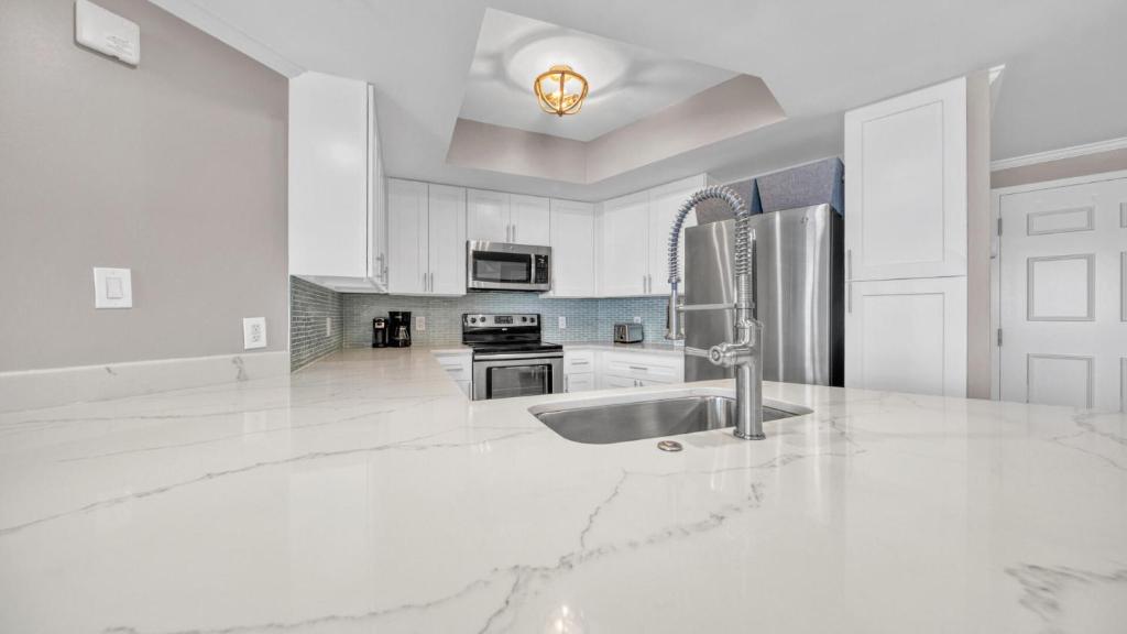 德斯坦St Maarten 907 a Newly Renovated Luxury Beach Front 3 Bedroom 9th Floor Private Elevator的白色的厨房配有水槽和冰箱