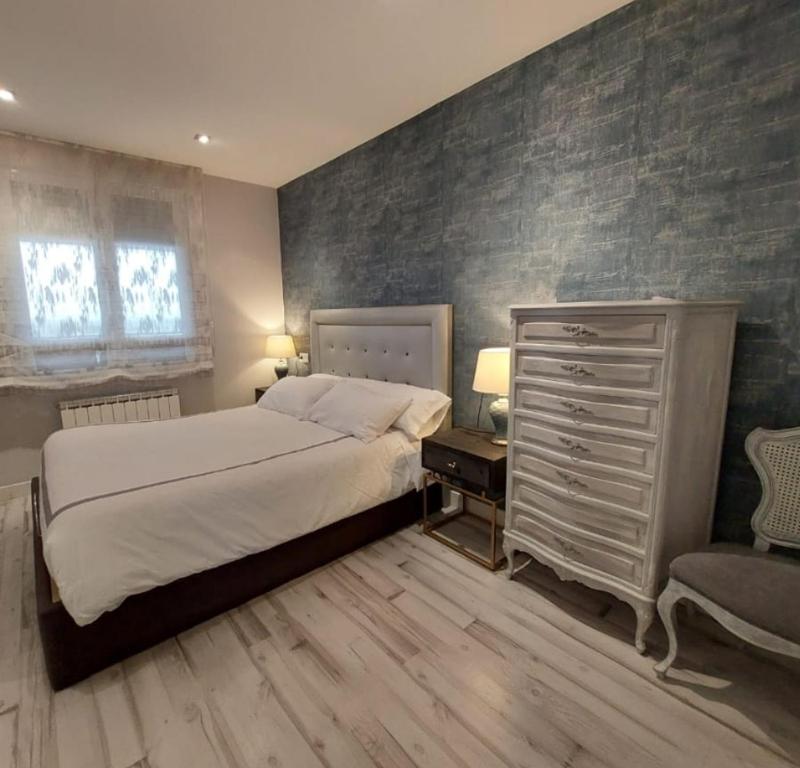 蓬费拉达El Silencio de Galadhrim的一间卧室配有一张床、梳妆台和椅子