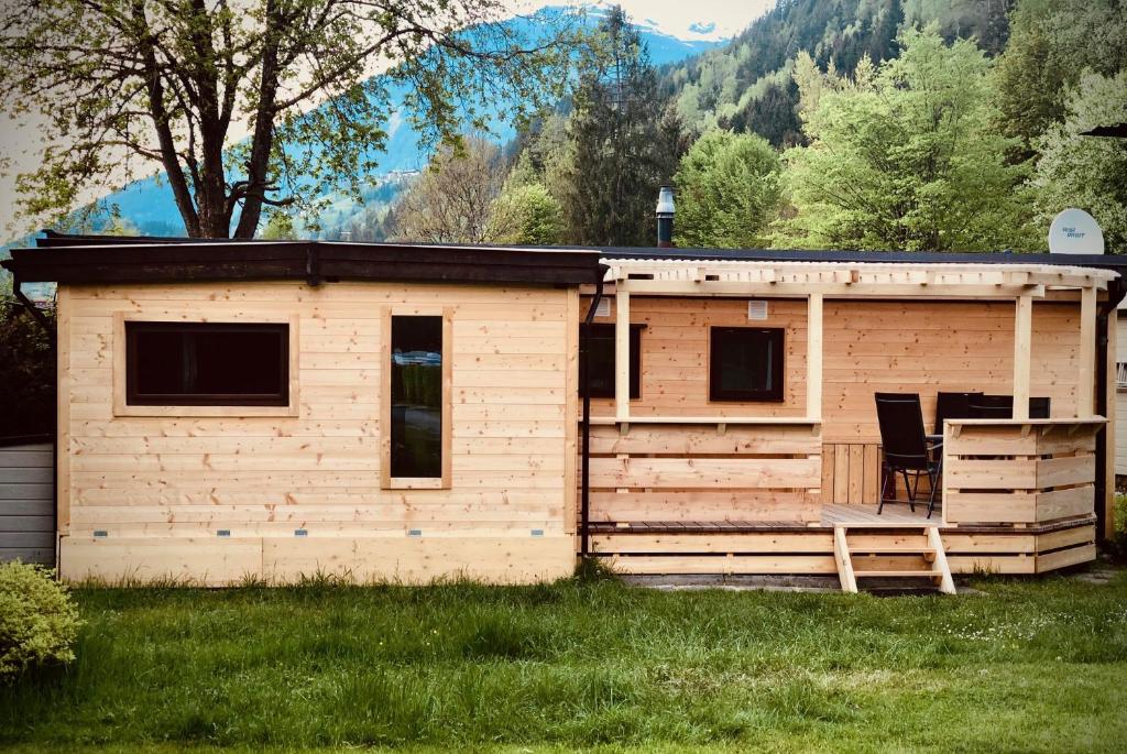 阿绍Mountainview Lodge - Chalet im Zillertal direkt am 5 Sterne Campingplatz Aufenfeld mit Hallenbad und Sauna的大型小木屋,设有草地门廊