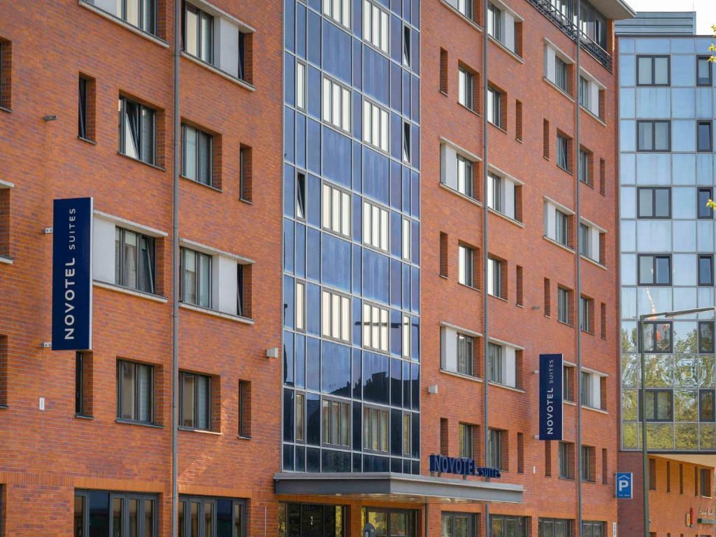 柏林柏林市波茨坦广场诺富特套房酒店的一座高大的砖砌建筑,上面有蓝色的标志