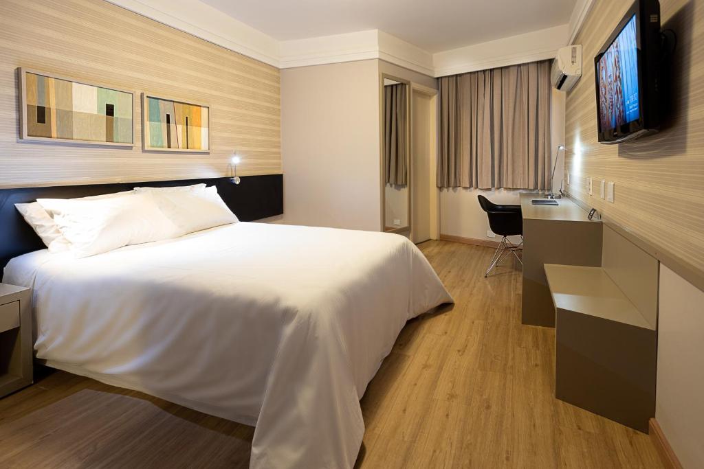 马里利亚Momax Hotel的酒店客房设有白色的床和电视。
