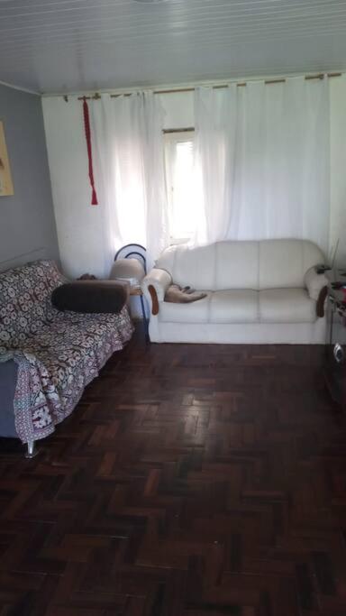 卡庞达卡诺阿Casa - ótima localização的一间设有白色沙发和窗户的客房