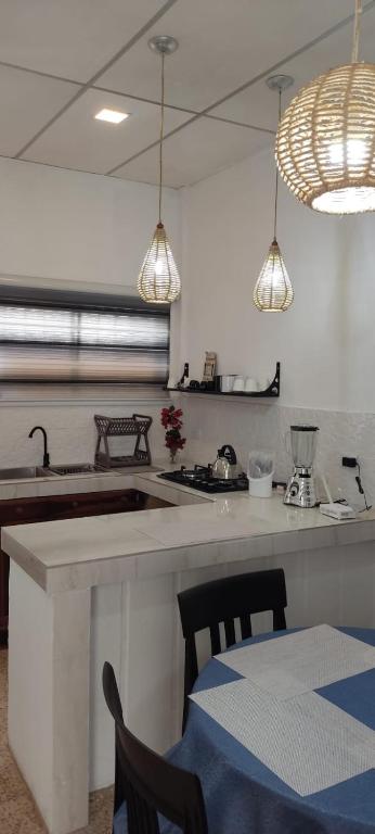 萨利纳斯Casa Salinas的厨房配有水槽和带椅子的柜台。