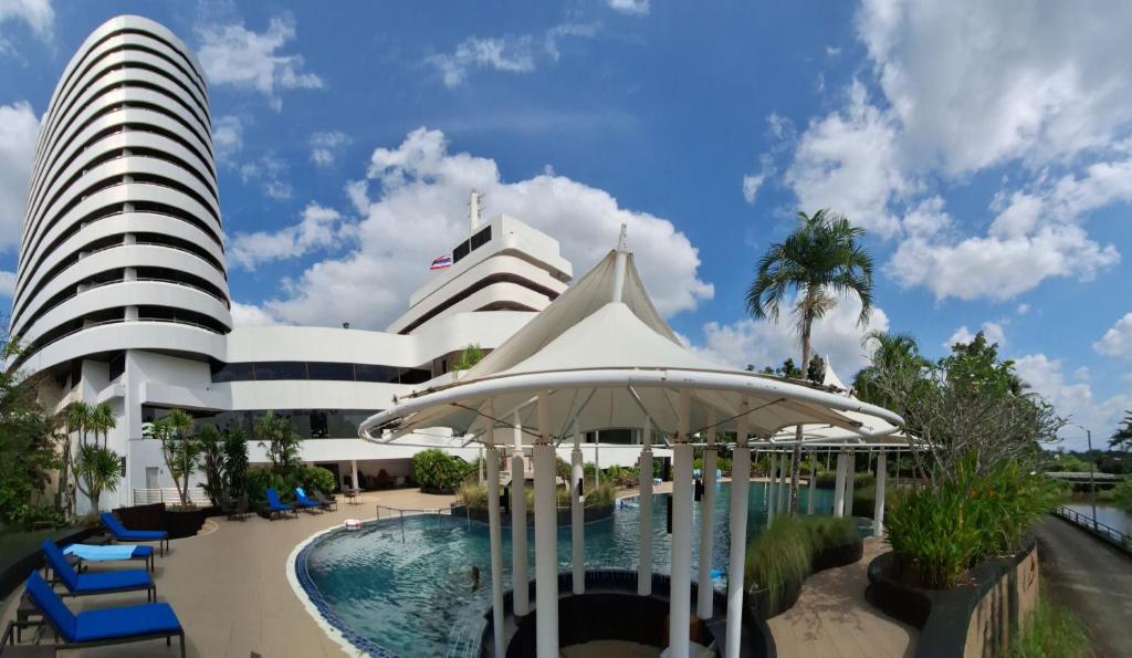 董里Rua Rasada Hotel - The Ideal Venue for Meetings & Events的一座带游泳池和大楼的酒店