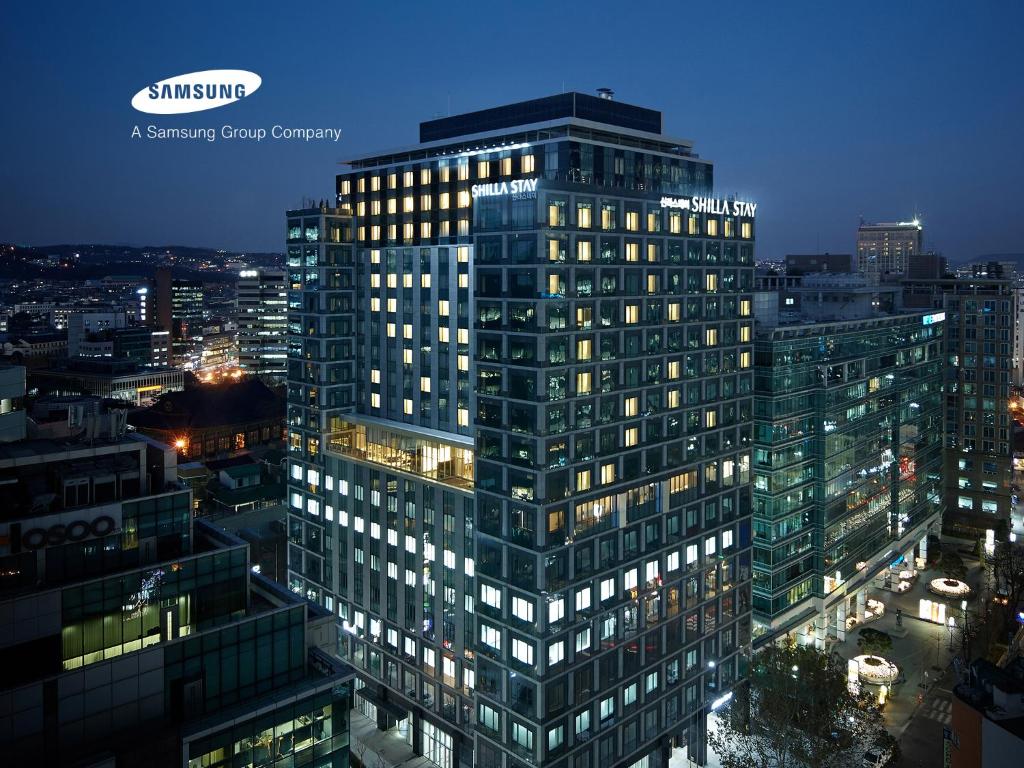首尔Shilla Stay Gwanghwamun Myeongdong的一座高大的建筑,晚上在城市里亮着灯