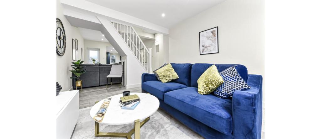 特威克纳姆City Elegance: Spacious 2BR for Urban Comfort的客厅配有蓝色的沙发和桌子