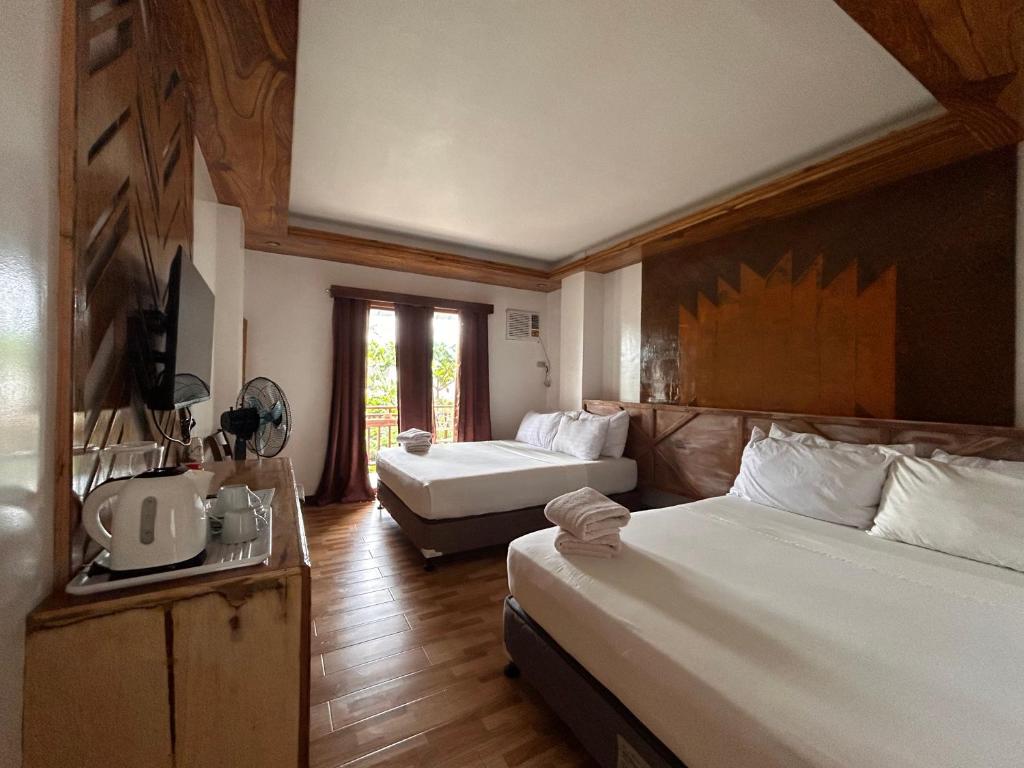 卢纳将军城Puyo Suites Homestay的酒店客房,设有两张床和一张沙发