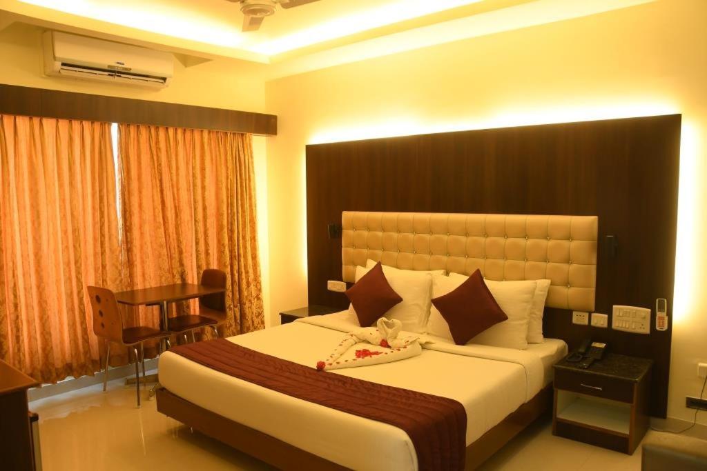 蒂鲁琴杜尔Hotel SR Tiruchendur的酒店客房设有一张大床和一张书桌。