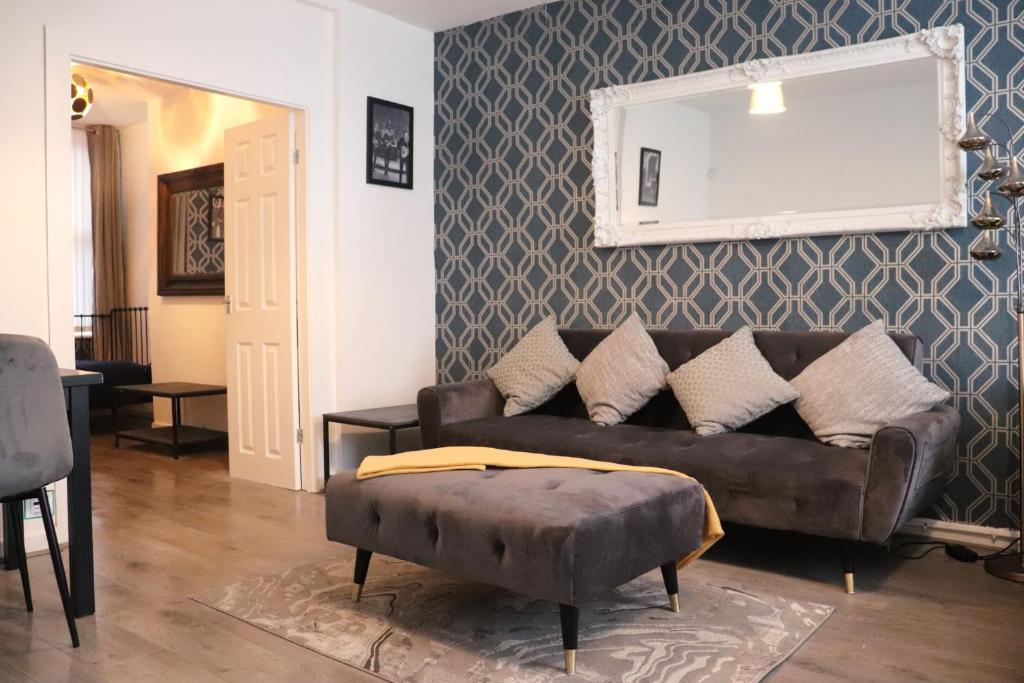 利物浦Goodison Accommodation的客厅配有棕色的沙发和镜子