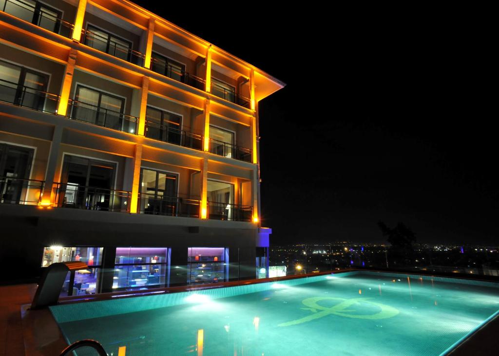 伯萨Hotel Çelik Palas Convention Center & Thermal SPA的建筑前的一座带游泳池的建筑