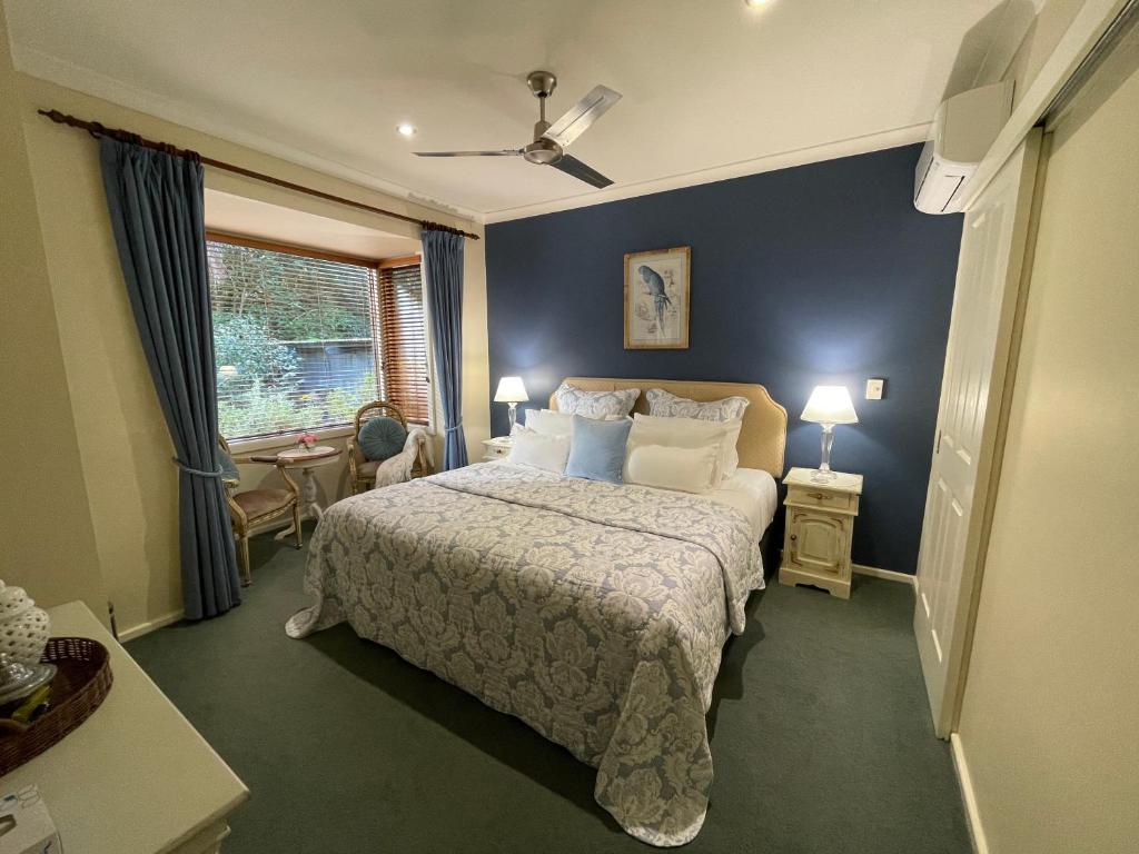 玛格丽特河紫檀木宾馆的一间卧室配有一张蓝色墙壁的床和一扇窗户