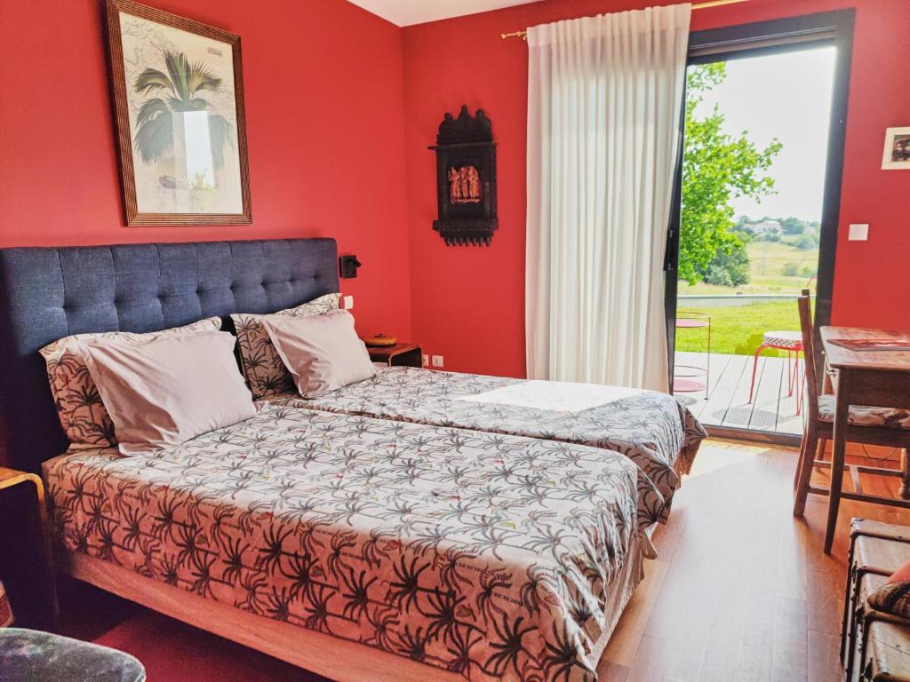 波格尔la Palisse的一间卧室设有一张红色墙壁和窗户的床