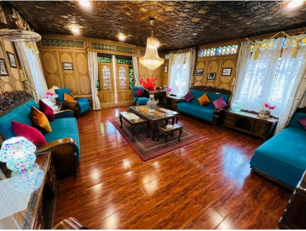 斯利那加The Hayat Group Of Houseboats的客厅配有蓝色的沙发和桌子