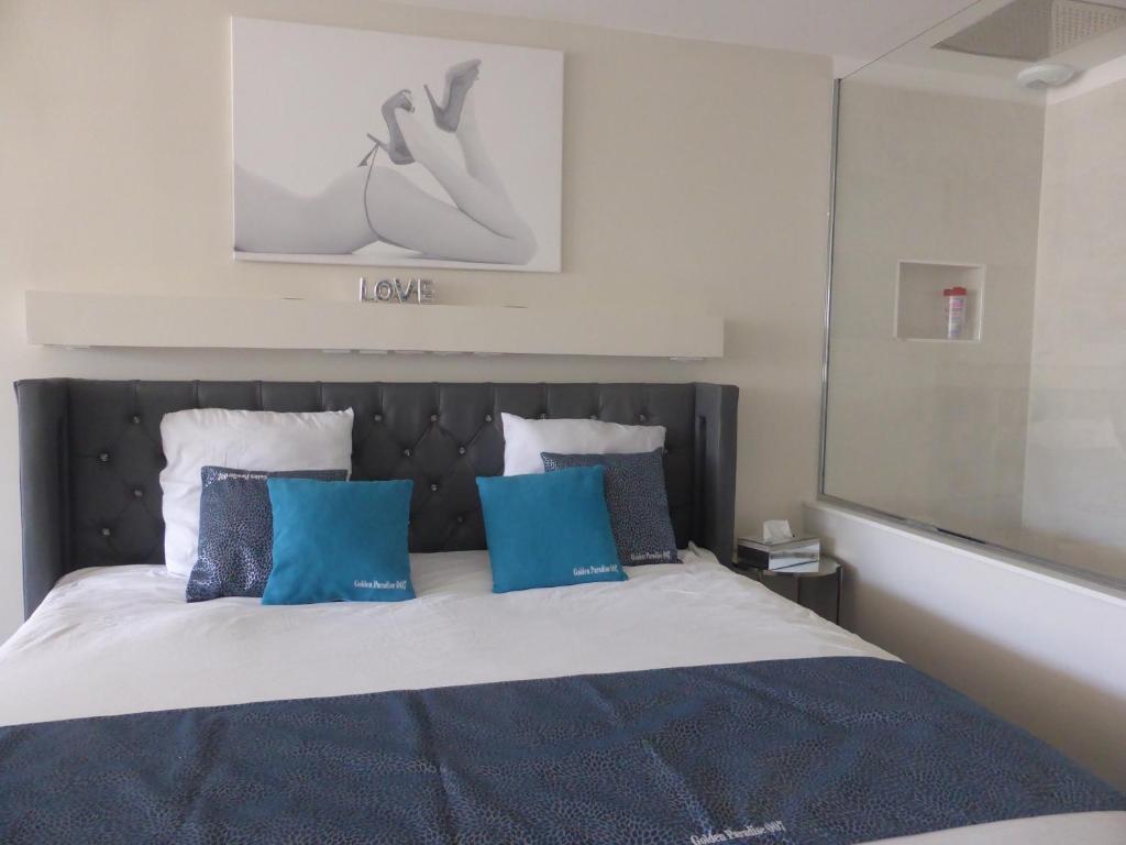 阿格德角Golden Paradise 007 Helio 66的一间卧室配有一张带蓝色枕头的床