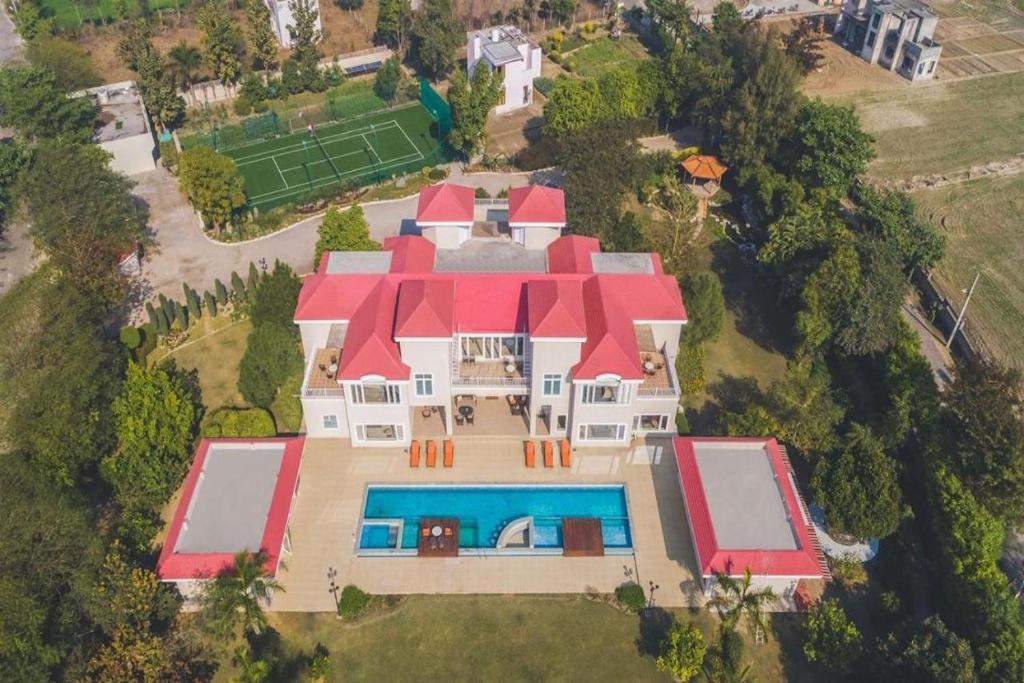 法里达巴德BluSalzz Collection - Siddha Wellness Village, Faridabad - Haryana的享有带游泳池的大房子的顶部景色