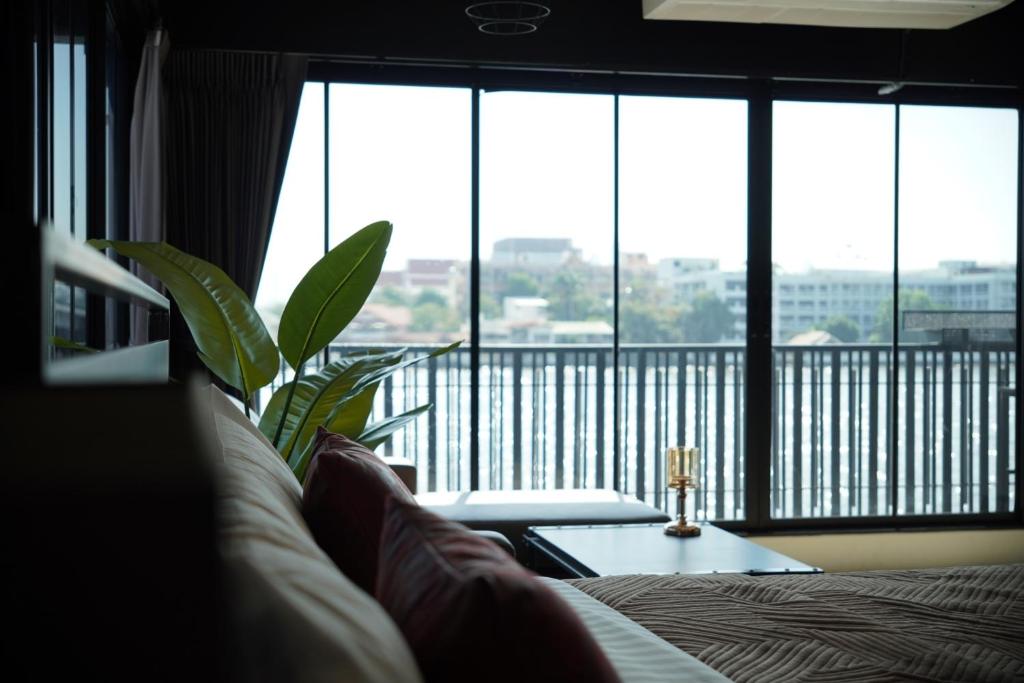 曼谷NORN Riverside Bangkok Hotel - นอนริมน้ำ的带沙发和大窗户的客厅