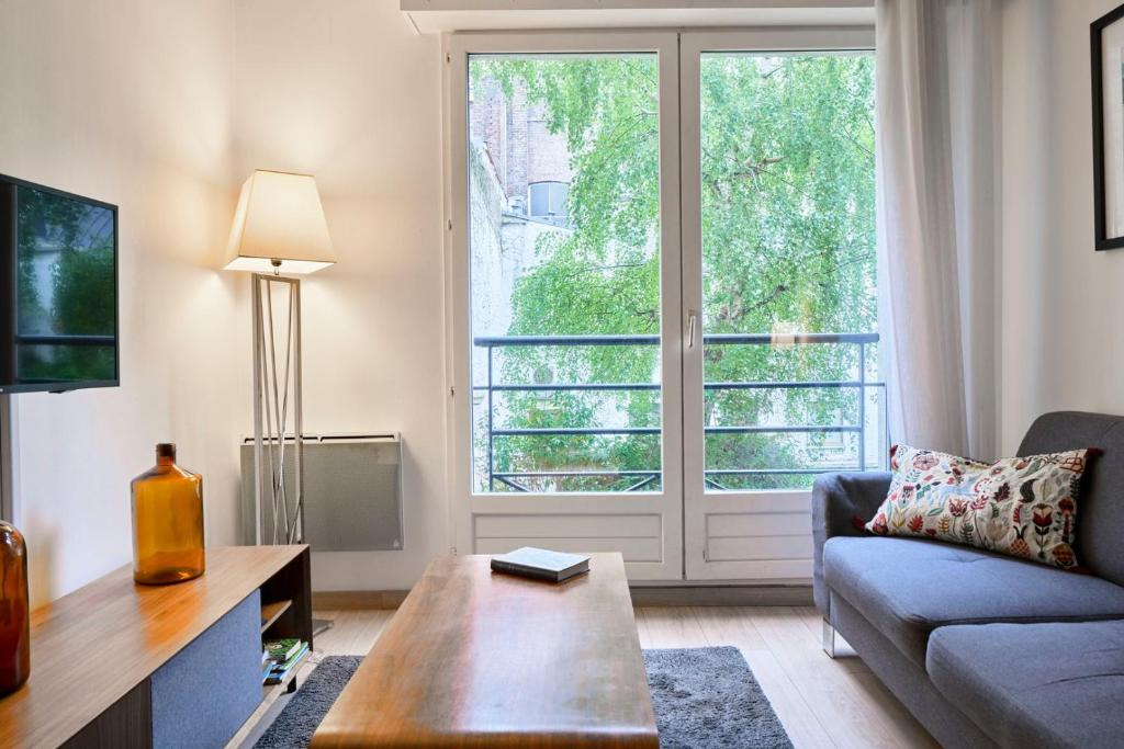 里尔Lille Centre - Superb bright apartment parking的带沙发和大窗户的客厅