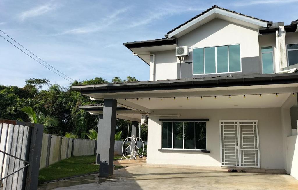 Kota SamarahanHomestay @Seri Sindang Guesthouse的白色的房子,有门和栅栏