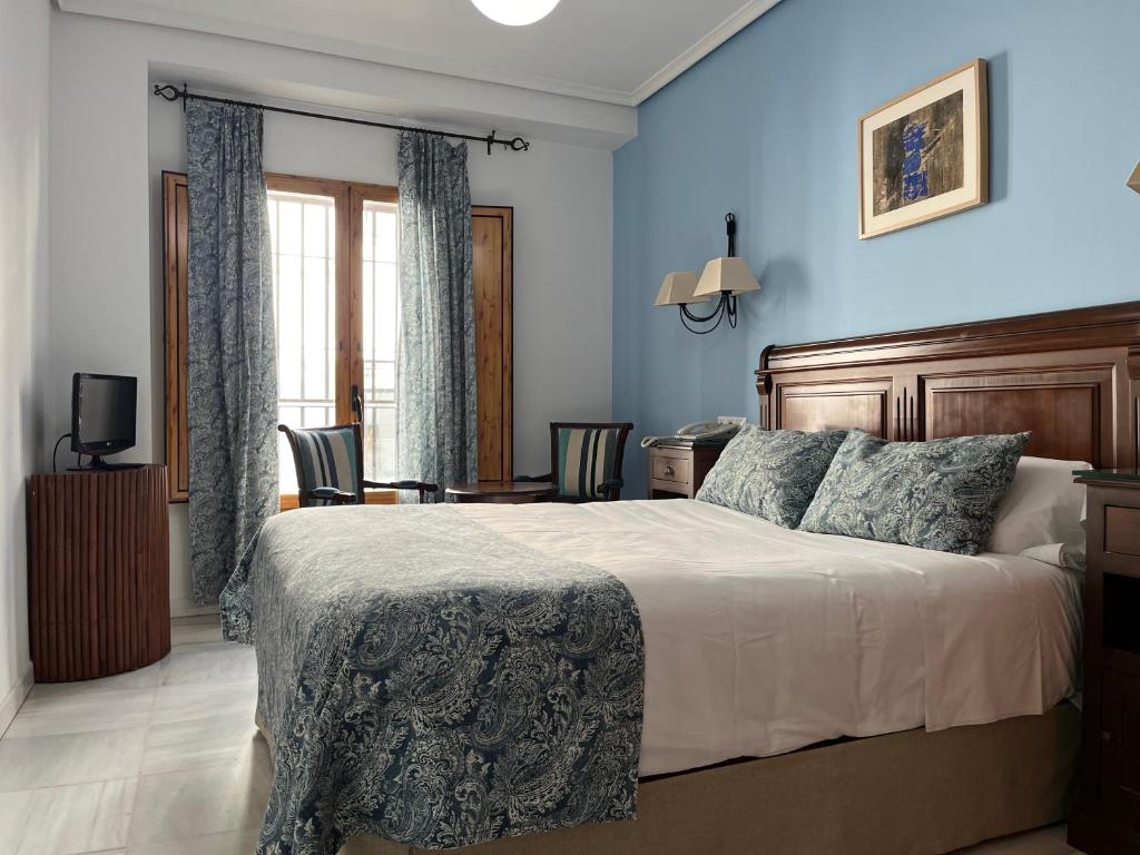 科尔多瓦梅斯特雷酒店的一间卧室配有一张带蓝色墙壁的大床
