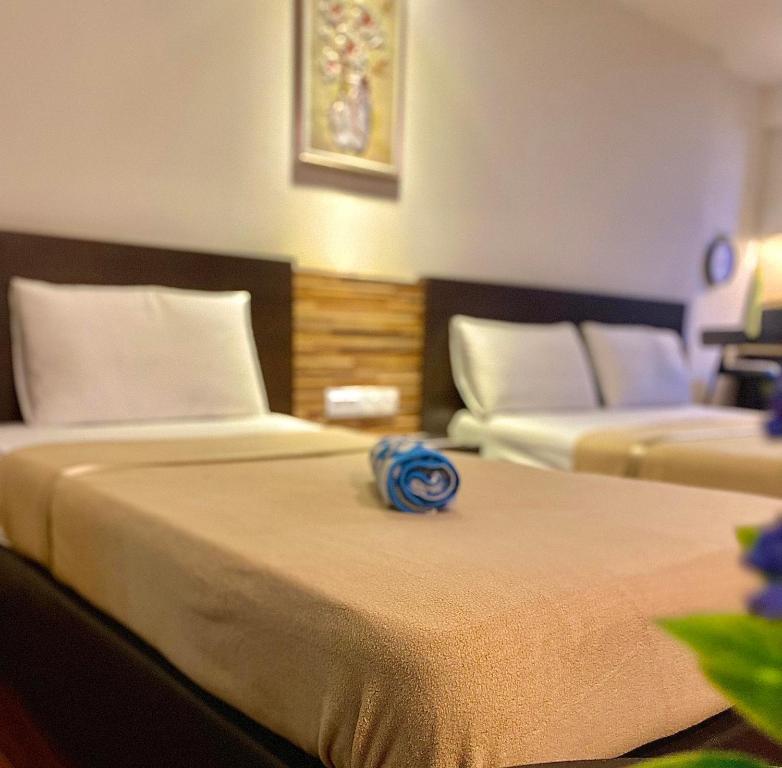 哥打巴鲁艾因一室公寓的酒店客房的顶部设有两张蓝色花卉床。