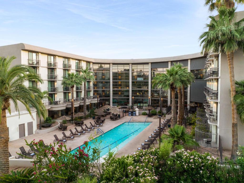 凤凰城Embassy Suites by Hilton Phoenix Biltmore的享有酒店外景,设有游泳池和棕榈树