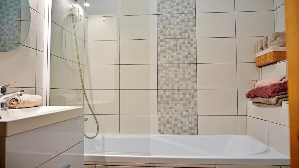 基什孔豪洛什Főtér Apartman的带淋浴、浴缸和盥洗盆的浴室