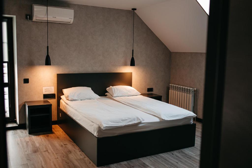 SamostrelyBastion的一间卧室配有一张带白色床单的大床