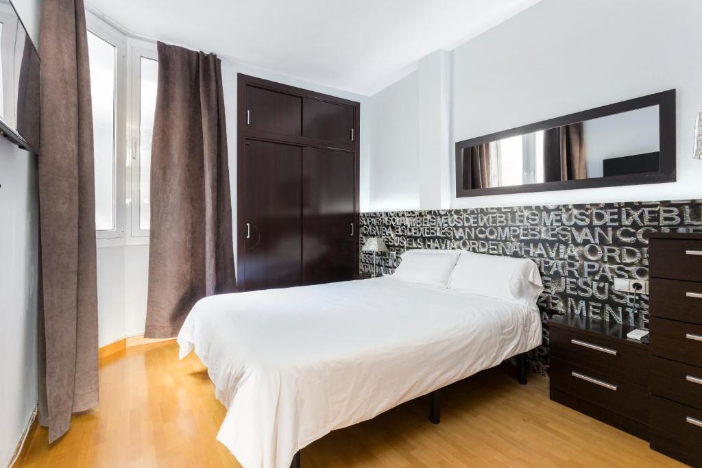巴塞罗那最佳巴塞罗纳公寓的一间卧室配有一张床、一个梳妆台和电视。