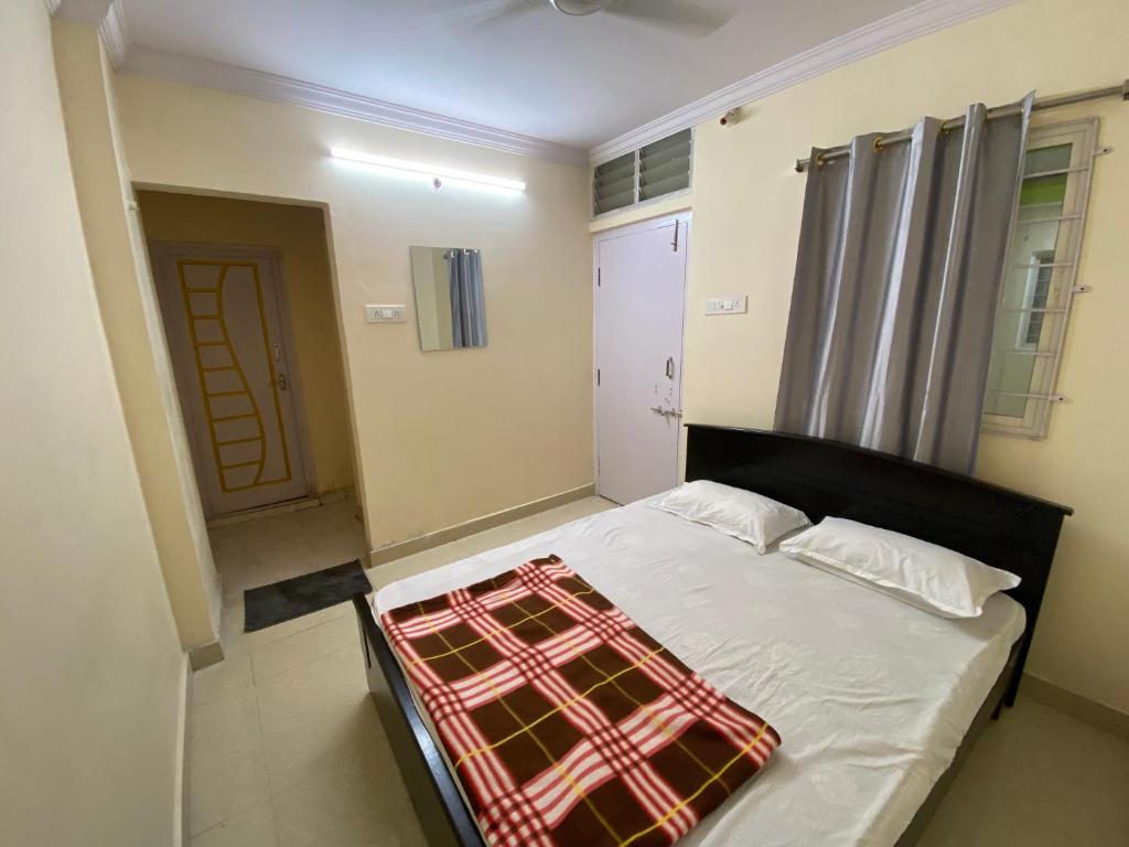 海得拉巴Hotel Plaza Rooms的一间卧室配有一张床,床上铺有铺着条纹毯子