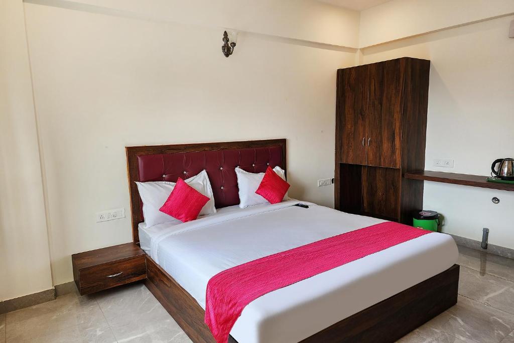 班加罗尔FabHotel KSP Kings Inn的卧室配有带红色枕头的大型白色床