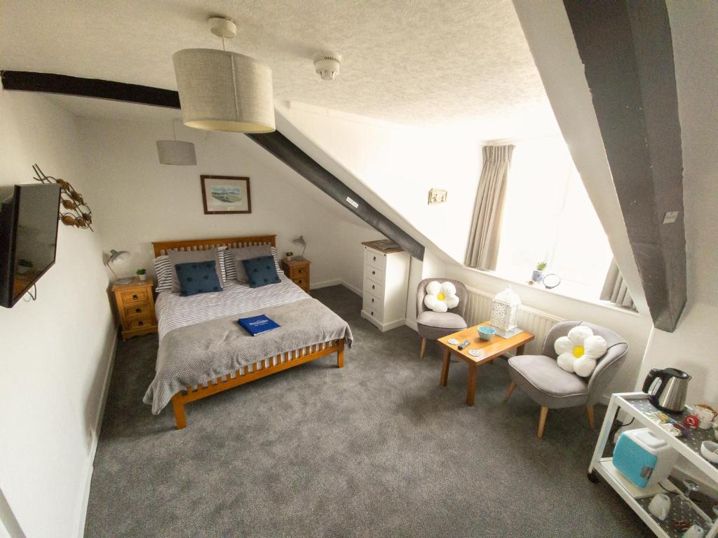 滕比比奇科默住宿加早餐酒店的一间带大床和楼梯的卧室