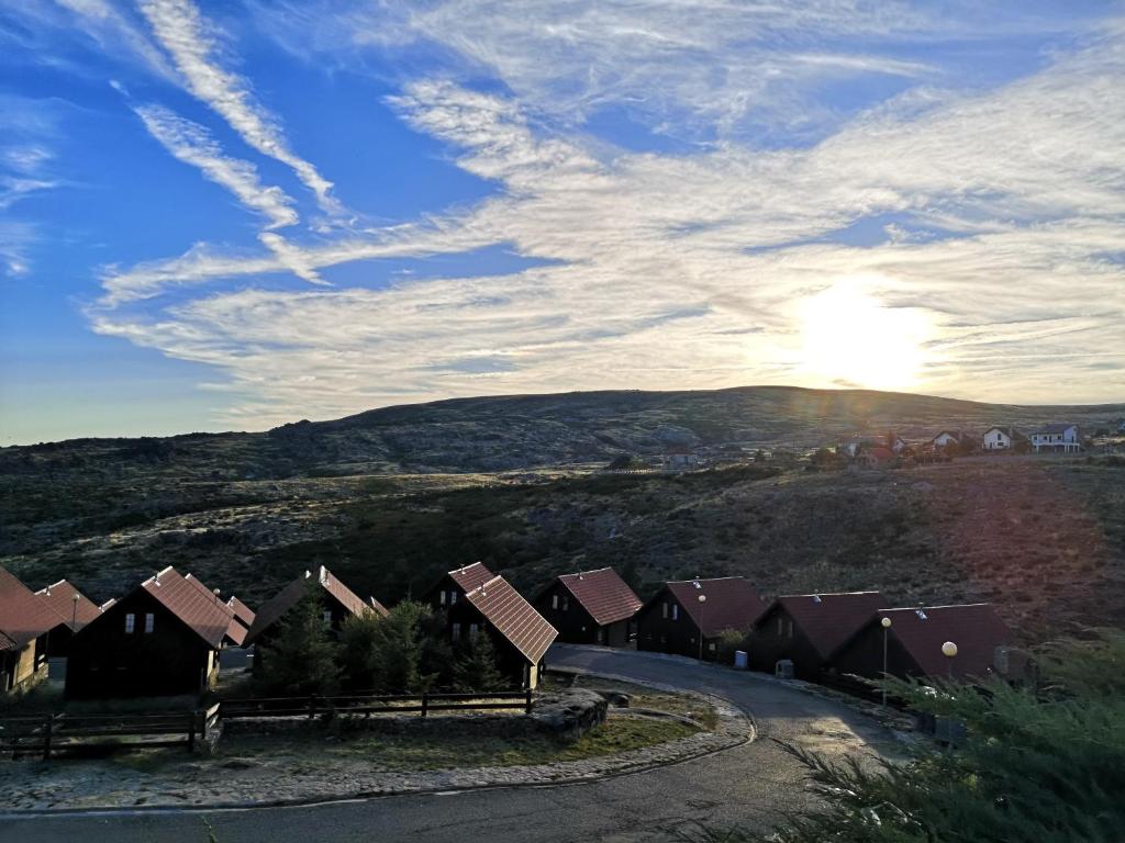 科维良Mountain Lodge T3 Duplex Abrigo do Lobo的山上的房子,阳光照在天空中